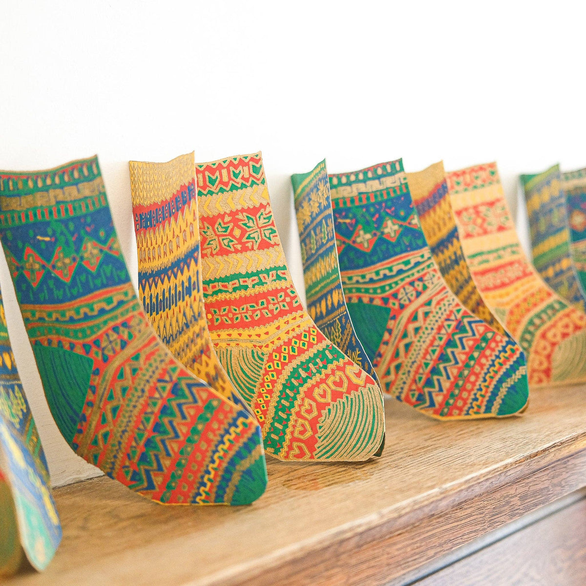 Knitted Christmas Stockings Screen Printed Concertina Garland on mantlepiece by penny black