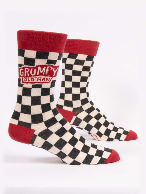 A pair of checkerboard black and white socks with red toes, heels and top edge. In red and white writing each sock on the outer edge says 'grumpy old man' in an Americana style.