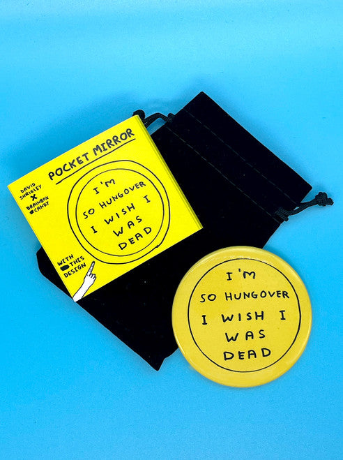 A yellow round pocket mirror with black handwriting saying I&#39;m so hungover I wish I was dead by artist DAvid Shrigley. There is a black velvet drawstring pouch that is comes in and bright yellow packaging to match.